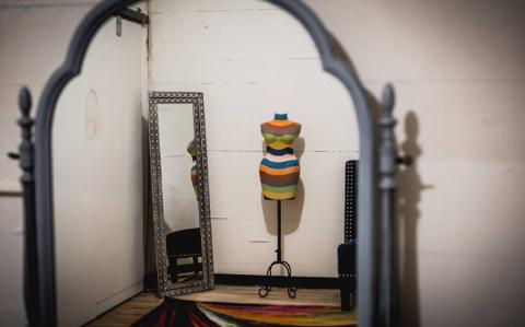 Arched mirror and striped vintage dress form in the getting-ready suite